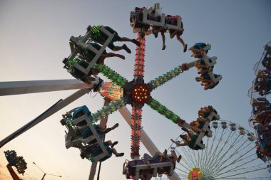 Akşamları ve akşamları lunaparktaki çocuk atlıkarıncasında. Geceleyin eğlence parkı. Lunapark, arka plan için resim.