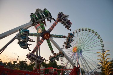 Akşamları ve akşamları lunaparktaki çocuk atlıkarıncasında. Geceleyin eğlence parkı. Lunapark, arka plan için resim.