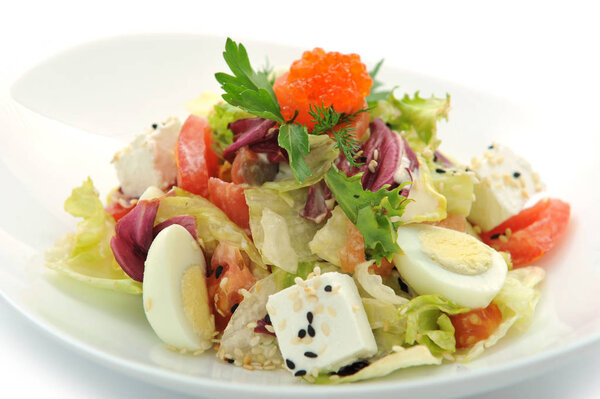 fresh salad with caviar and salmon on white bowl 