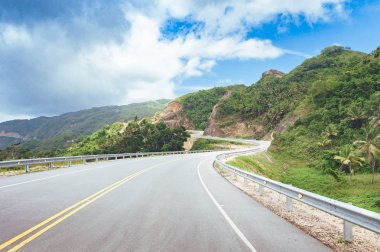 yol geçiş orman ve tepeler ile bulutlu gökyüzü arka plan üzerinde  
