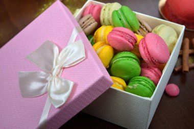 Ahşap masa kopya alanı için arka plan ile renkli Fransızca veya İtalyanca macaron yığını. Macarons veya macaroons olduğunu Fransız tatlı öğleden sonra çay veya kahve molası ile hizmet