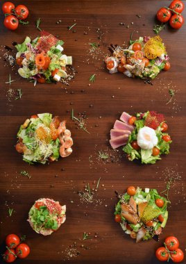 Taze salata tavuk, domates ve ahşap zemin üzerine karışık yeşillik (roka, mesclun, mache) kapatın. Sağlıklı gıda