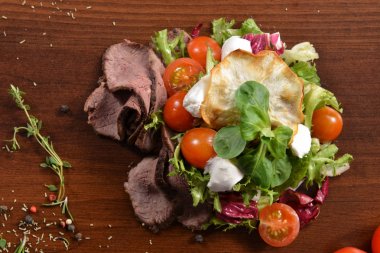 Sezar salata kasesi kadar kapatın. Sağlıklı salata tabağı domates, Beacon, ahşap arka plan üstten görünüm üzerinde. Gıda ve sağlık