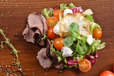 Sezar salata kasesi kadar kapatın. Sağlıklı salata tabağı domates, Beacon, ahşap arka plan üstten görünüm üzerinde. Gıda ve sağlık