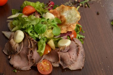 Sezar salata kasesi kadar kapatın. Sağlıklı salata tabağı domates, Beacon, ahşap arka plan üstten görünüm üzerinde. Gıda ve sağlık