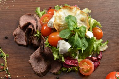 Sezar salata kasesi kadar kapatın. Sağlıklı salata tabağı domates, Beacon, ahşap arka plan üstten görünüm üzerinde. Gıda ve sağlık