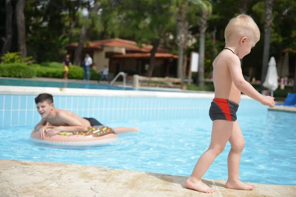 Счастливый ребенок играет в бассейне. Летние каникулы — стоковое фото