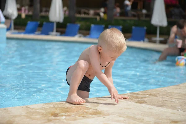 Счастливый ребенок играет в бассейне. Летние каникулы — стоковое фото