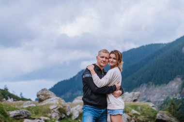 Dağlarda romantik yaz aşk hikayesi bir günbatımı üzerinde. Genç kız ve erkek aşık.