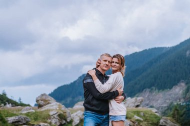 Dağlarda poz veren gülümseyen çift 