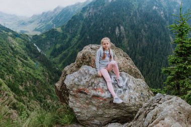 Transfegerasan dağ yolunun yanındaki uçurumun kenarındaki kız.