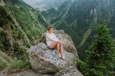 Transfegerasan dağ yolunun yanındaki uçurumun kenarındaki kız.