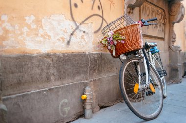 Grafiti hasarı altında duvara yaslanan Retro tarzı bisiklet.