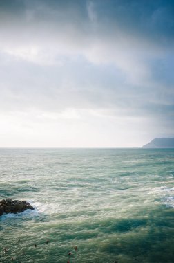 Karanlık denizin üzerinde fırtınalı bir gökyüzü.