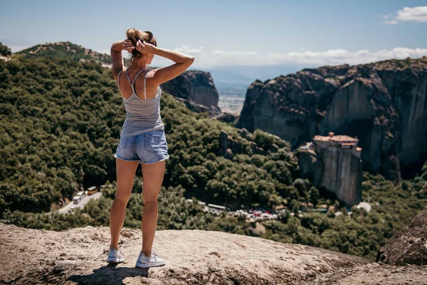 한 소녀가 메테오라 - 그리스 - 의 절벽에 서서 골짜기를 바라봅니다. 여름 방학 — 스톡 사진