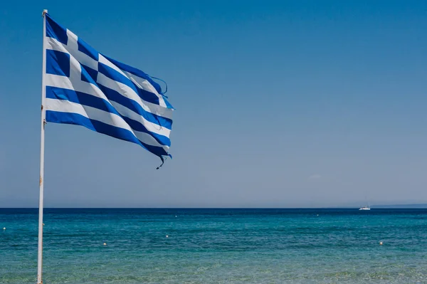 Bandeira grega no penhasco com mar azul no fundo — Fotografia de Stock