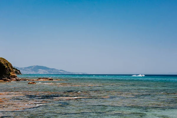 Spiaggia tranquilla con isola dorata e sabbia al tramonto, mare con acqua calma, Grecia — Foto Stock