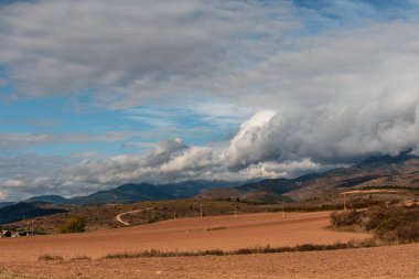Gün boyunca bulutlarla çevrili dağların manzarası