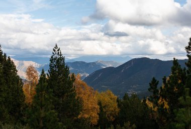 Gün boyunca bulutlarla çevrili dağların manzarası