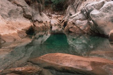 Taşlarla çevrili berrak sularla dolu bir nehir.