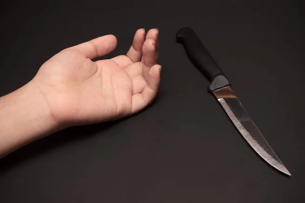 Cuchillo afilado al lado de la mano — Foto de Stock
