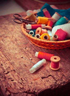 eski makas ve bobin iplik ve eski ahşap zemin üzerine iğne ile