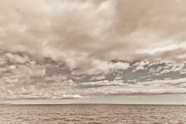 okyanus sakin su ve beyaz kabarık bulutlar gökyüzü üzerinde 