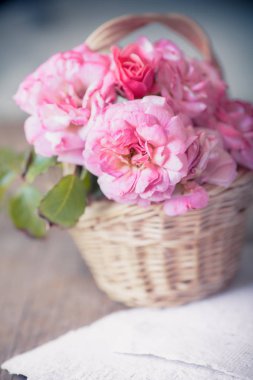 Pembe gül sepeti beyaz el ile kağıt üzerinde ahşap masa arka plan yaptı. 