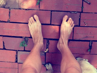 iki yalınayak ayak üzerinde kırmızı tuğla zemin, açık arka plan