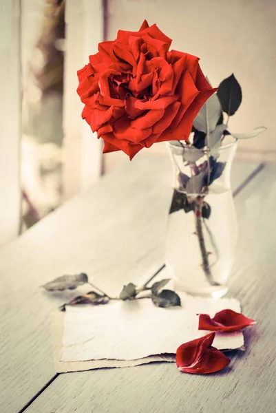 木製テーブル バレンタイン日コンセプトの紙とガラスの花瓶のローズ — ストック写真