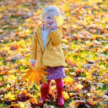 Küçük kız ormanda veya parkta güneşli bir gün zevk