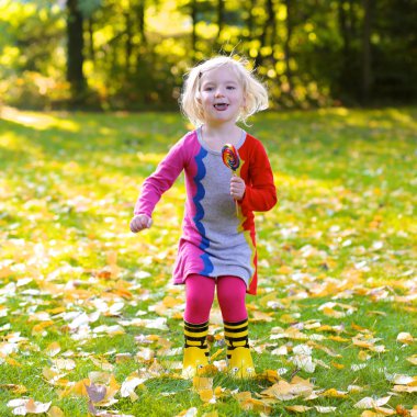 Küçük kız ormanda veya parkta güneşli bir gün zevk