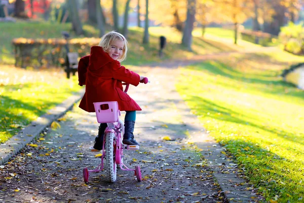 Klein meisje rijden fiets in het park — Stockfoto
