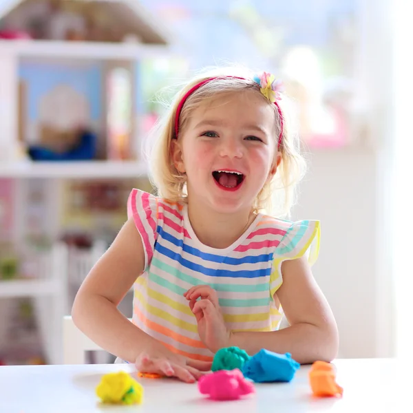 Niña preescolar jugando en el interior con plastilina — Foto de Stock