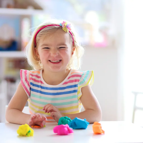 Niña preescolar jugando en el interior con plastilina —  Fotos de Stock