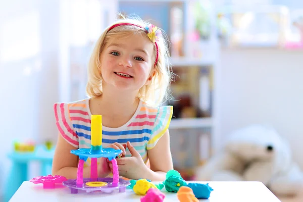 Ragazza in età prescolare che gioca in casa con la plastilina — Foto Stock