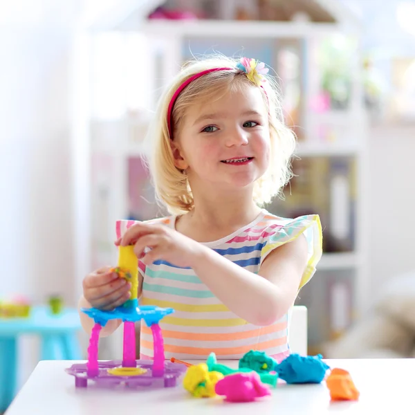 Niña preescolar jugando en el interior con plastilina — Foto de Stock