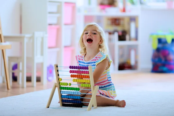 Förskolebarn flicka leker med trä leksak Abacus — Stockfoto
