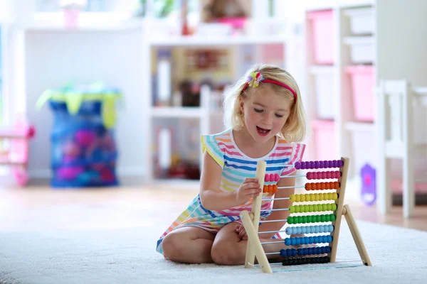Дошкольница, играющая с деревянными игрушками — стоковое фото