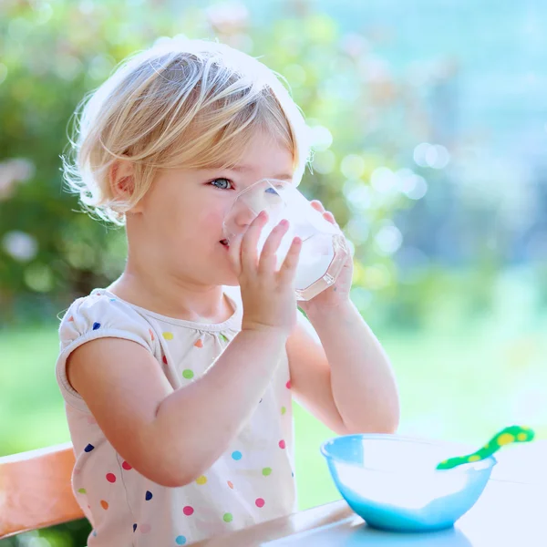 Toddler girl drinking milk from the glass — Stock Photo, Image