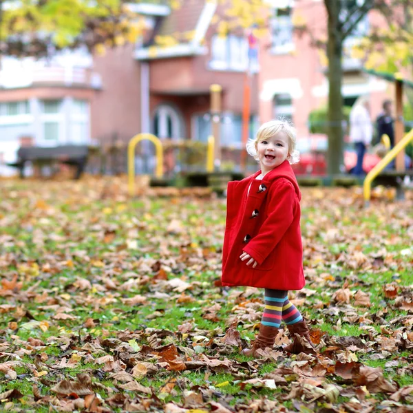 Активная маленькая девочка играет на детской площадке — стоковое фото