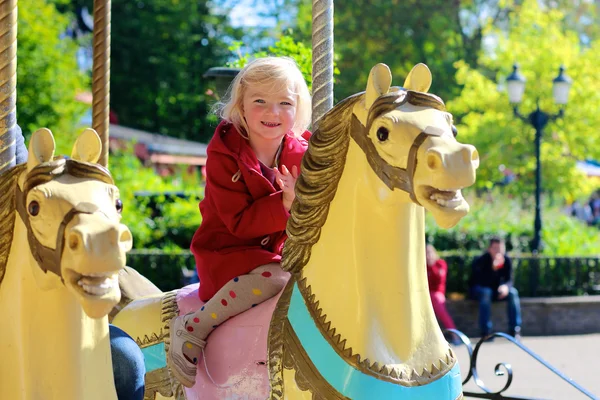 公園でメリーゴーランドを楽しむ小さな女の子 — ストック写真