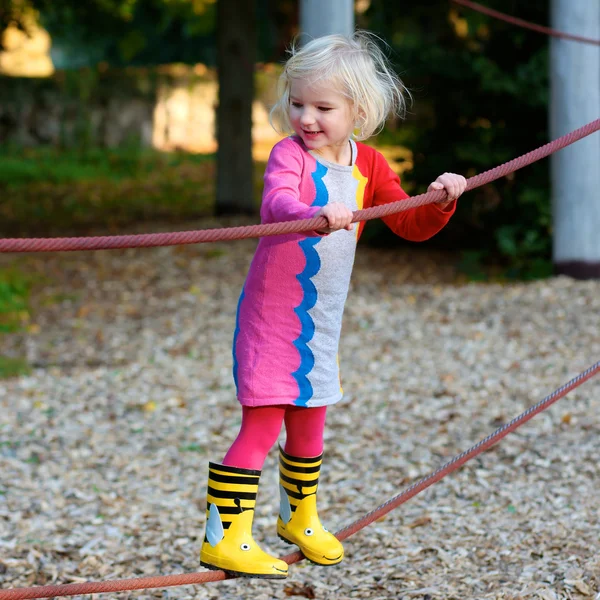 Aktives kleines Mädchen spielt auf dem Spielplatz — Stockfoto