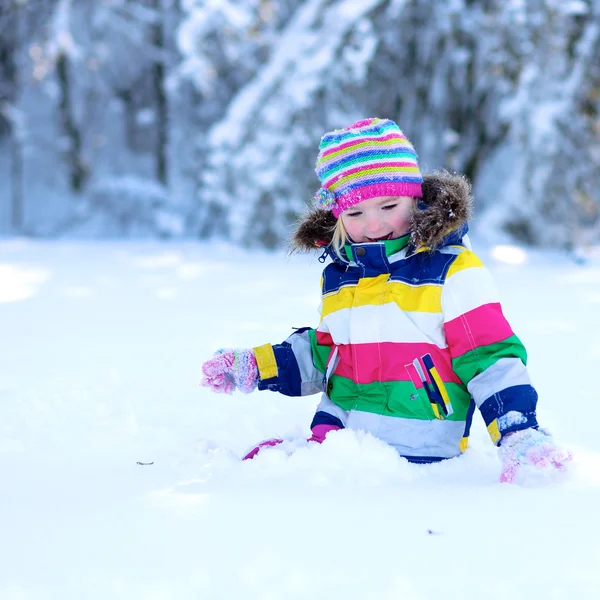 Маленькая девочка веселится на свежем воздухе в солнечный зимний день — стоковое фото