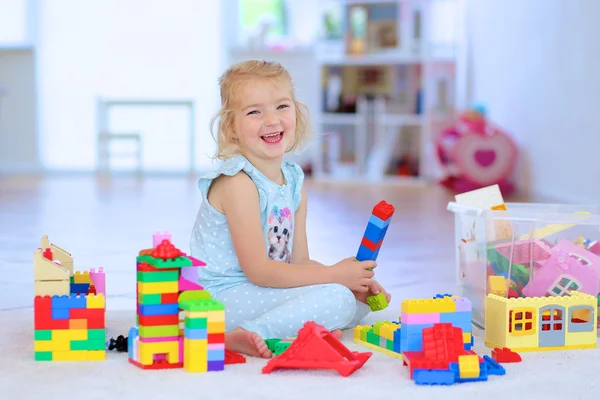 Niña jugando con ladrillos de construcción en el interior —  Fotos de Stock