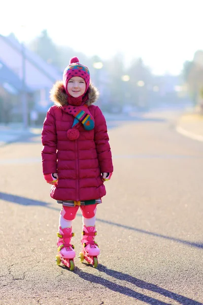 Happy little girl roller skating on the street — Stock Photo, Image