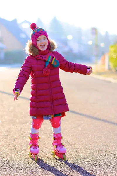Счастливая маленькая девочка катается на роликах по улице — стоковое фото