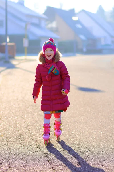 Happy little girl roller skating on the street — Stock Photo, Image