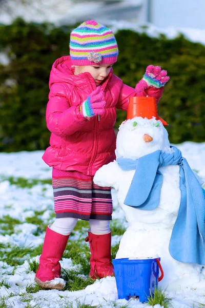 Маленький ребенок играет на открытом воздухе зимой — стоковое фото