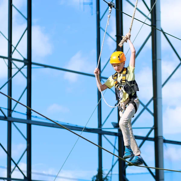 Un ragazzo che si arrampica nel parco avventura — Foto Stock